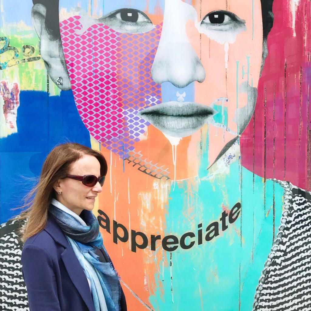 In front of one of the 12 portraits from the Faces of Regent Park, a downtown Toronto  neighborhood (By Toronto artist Dan Bergeron)